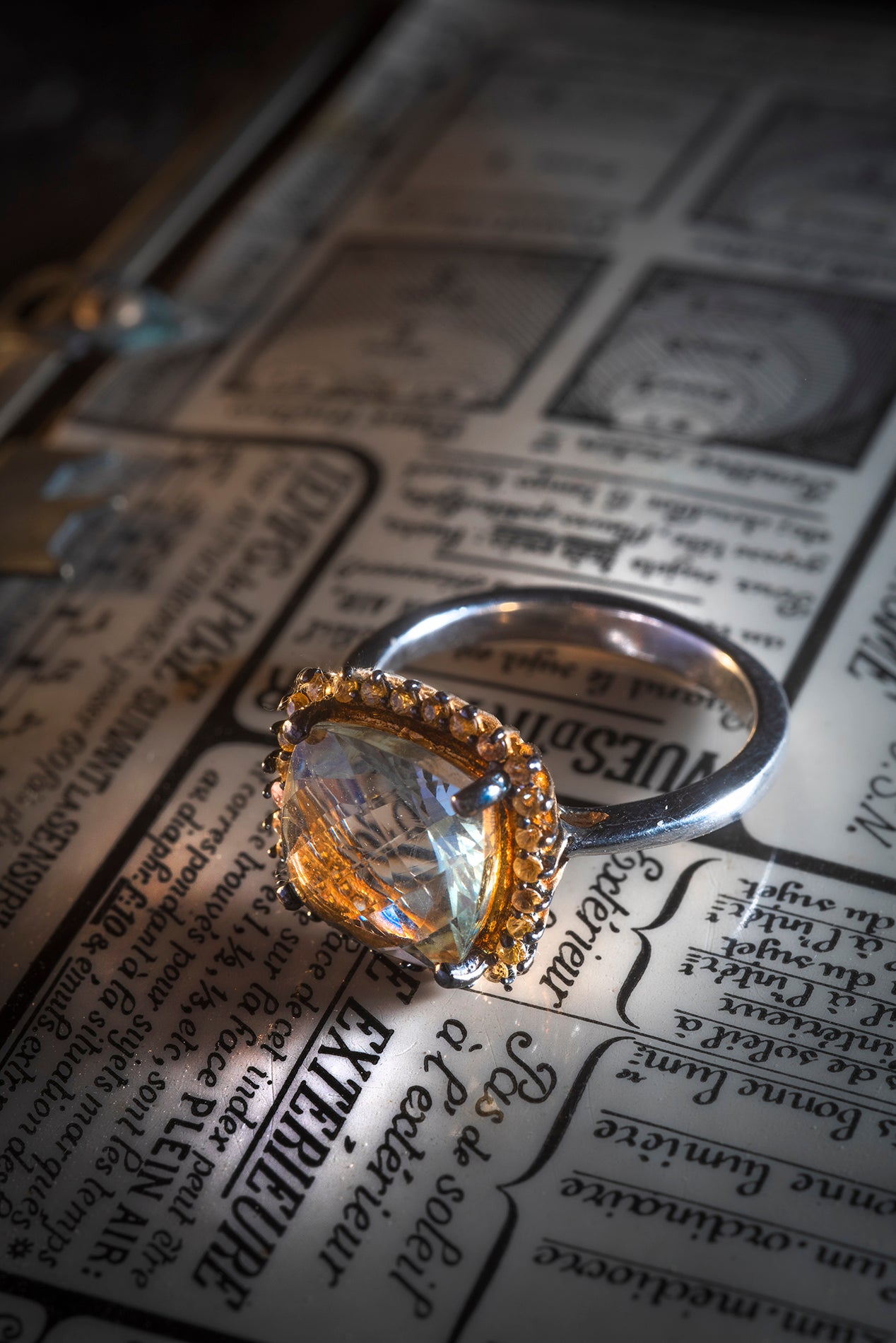 Bague en Argent 925 mm, centrée d’un quartz en briolette entouré de petits saphirs jaunes.